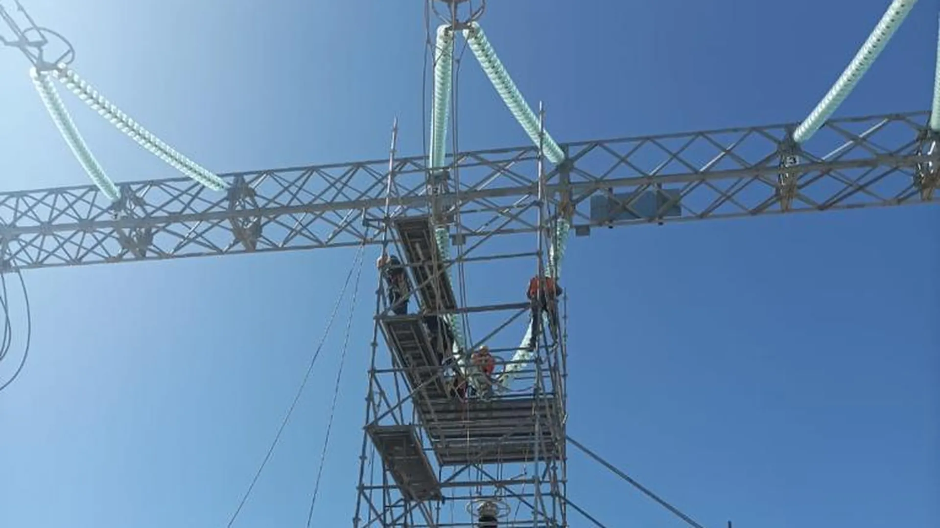 Cuadrilla trabajando sobre cadenas de aisladores recubiertas en blanco en una subestación del desierto de Atacama